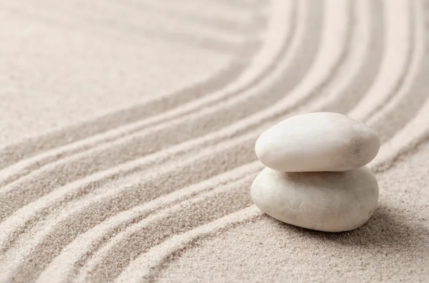 Three stones stacked on raked sand